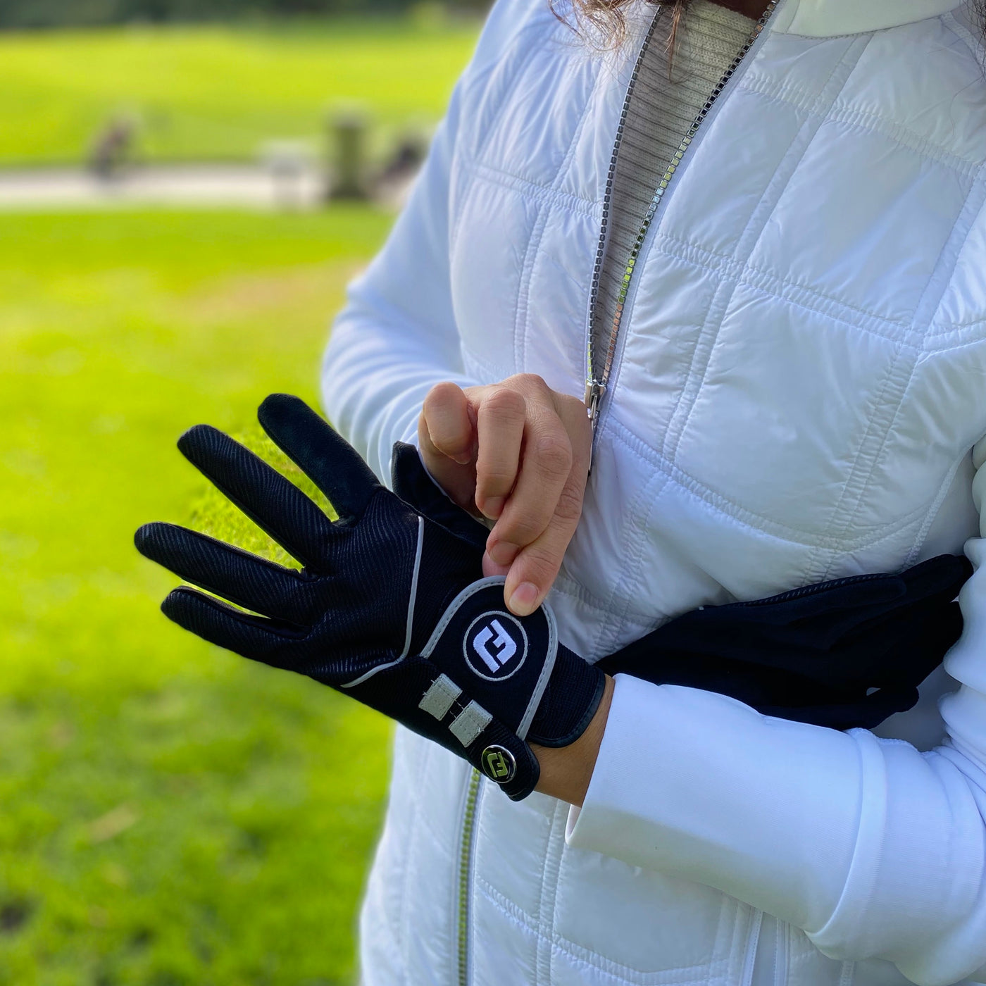 Golfers wearing weather gear on golf course