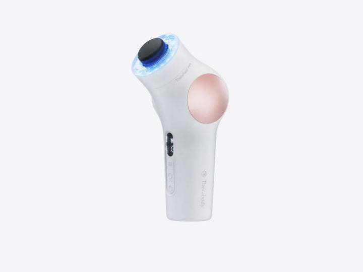 White TheraFace PRO facial massage gun by Therabody with blue light therapy ring against a white background.